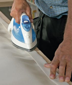 Segelduk: Vik in väven över den första sömmen så att det nu ligger tre lager väv på varandra. Segelduk: Vik in väven över den första sömmen så att det nu ligger tre lager väv på varandra.